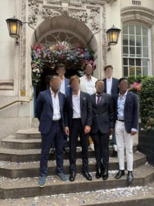 6 men outside steps of house